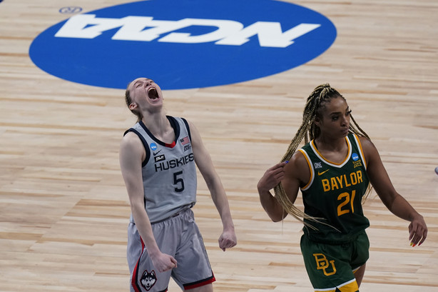 UConn guard Paige Bueckers (5) celebrates the team's win as Baylor guard DiJonai Carrington (21) walks off the court after a college basketball game in the Elite Eight round of the women's NCAA tournament at the Alamodome in San Antonio, Monday, March 29, 2021.