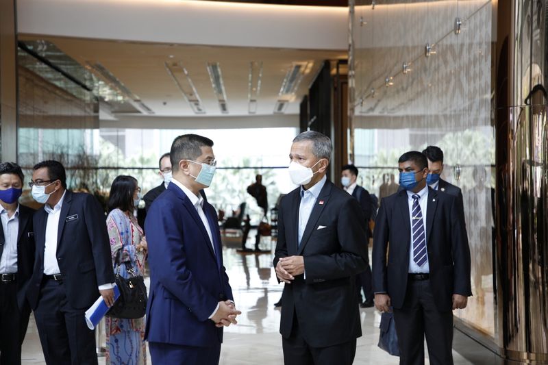 FILE PHOTO: Singapore's Minister for Foreign Affairs Dr Vivian Balakrishnan speaks with Malaysia's Senior Minister and Minister of International Trade and Industry Dato‘ Seri Mohamed Azmin Ali in Malaysia, in this March 24, 2021 handout photo. Singapore's Ministry of Foreign Affairs/Handout via REUTERS