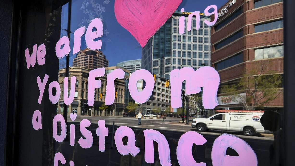 A hand-painted sign on a business in downtown Salt Lake
City on Monday, April 13, 2020, reminds Utahns to social
distance during the COVID-19 pandemic.