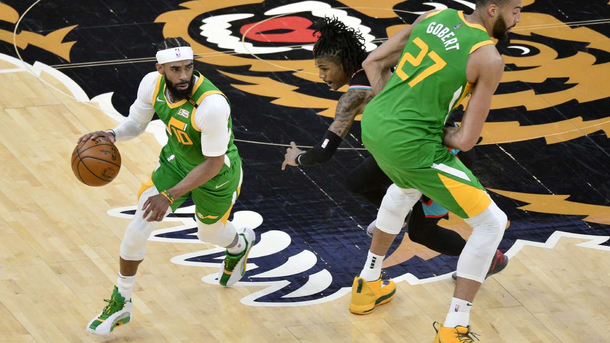 Utah Jazz guard Mike Conley (10) drives past Memphis Grizzlies guard Ja Morant with help from center Rudy Gobert (27) during the first half of an NBA basketball game Wednesday, March 31, 2021, in Memphis, Tenn. (AP Photo/Brandon Dill)