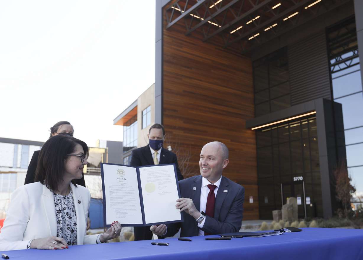 Lt. Gov. Deidre Henderson, left, and Gov. Spencer Cox display an executive order announcing the launch of the lieutenant governor's new returnship initiative outside of Northrop Grumman's offices in Roy on Thursday, April 1, 2021.
