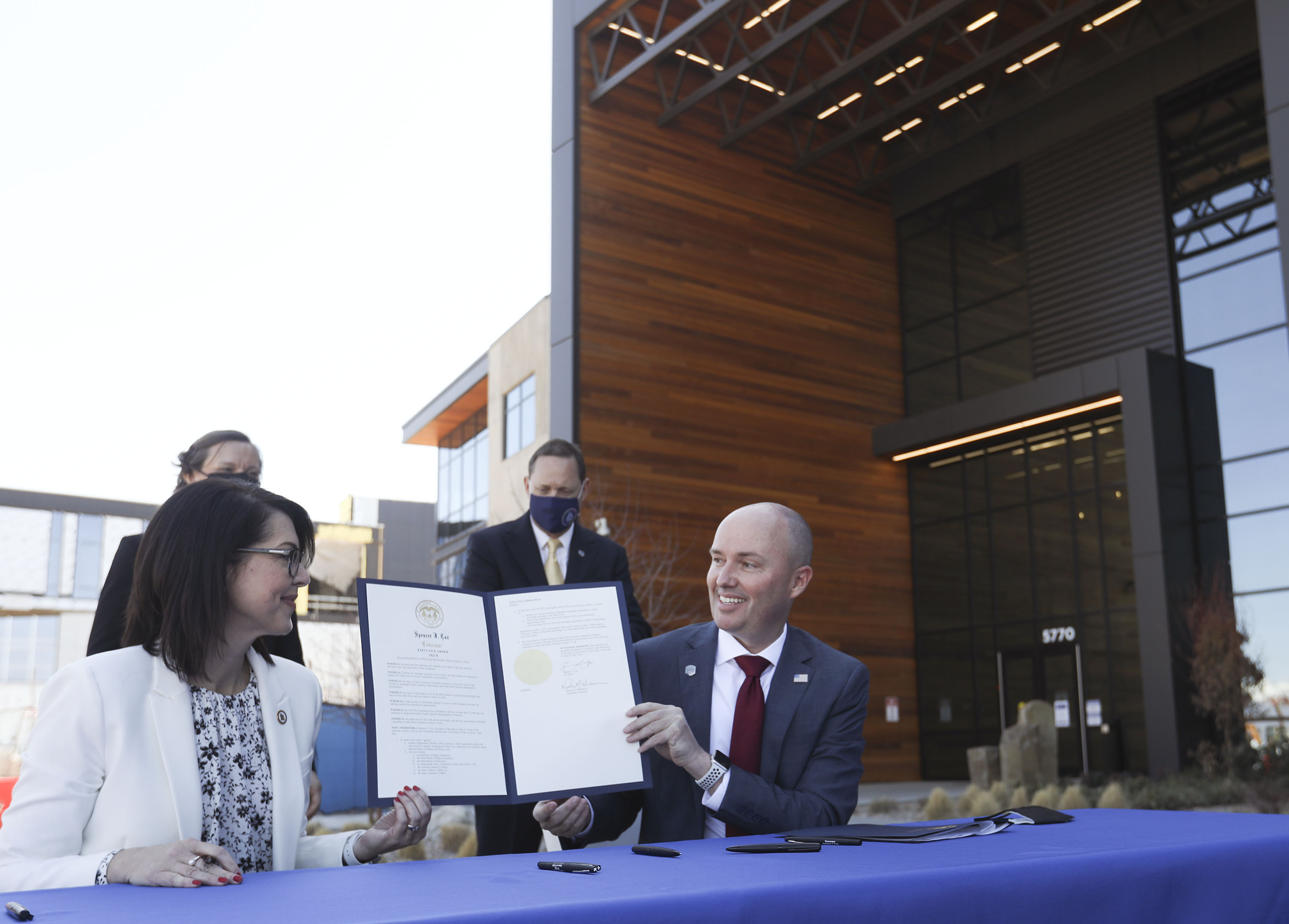Lt. Gov. Deidre Henderson, left, and Gov. Spencer Cox display an executive order announcing the launch of the lieutenant governorâs new returnship initiative outside of Northrop Grumman's offices in Roy on Thursday, April 1, 2021.