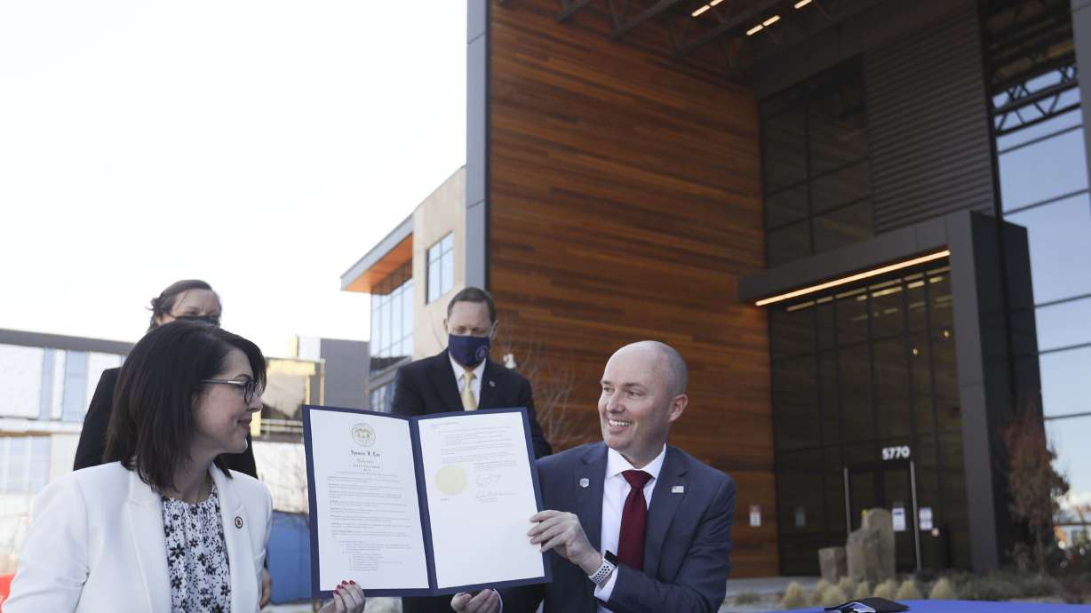 Lt. Gov. Deidre Henderson, left, and Gov. Spencer Cox display an executive order announcing the launch of the lieutenant governorâs new returnship initiative outside of Northrop Grumman's offices in Roy on Thursday, April 1, 2021.