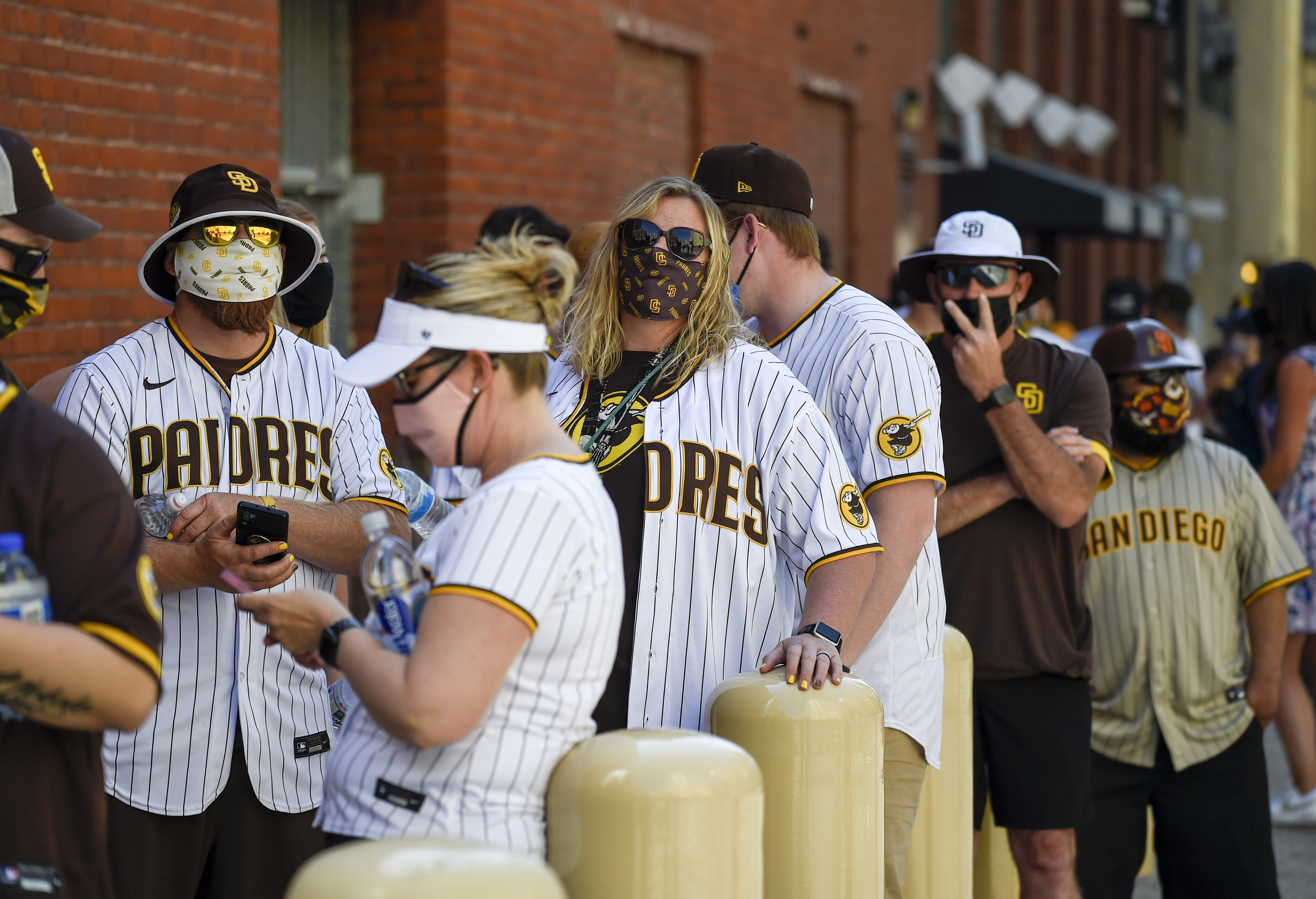 Baseball fans wait in line before the gates opened up before a baseball game between the Arizona Diamondbacks and the San Diego Padres Thursday, April 1, 2021, on opening day in San Diego. The U.S. moved closer Thursday toward vaccinating 100 million Americans in a race against an uptick in COVID-19 cases that is fueling fears of another nationwide surge just as the major league baseball season starts and thousands of fans return to stadiums.