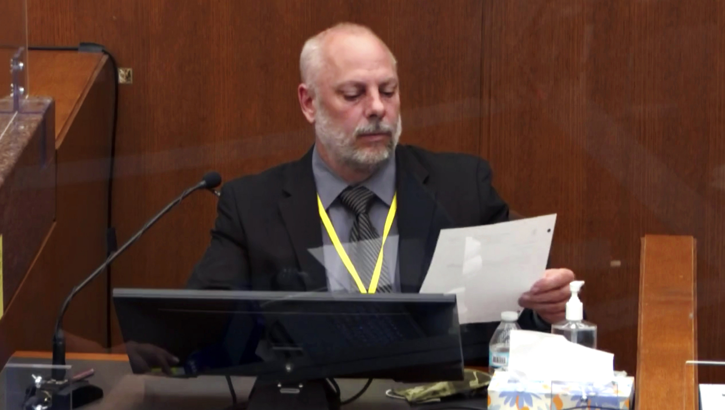 In this image from video, witness David Pleoger, a retired Minneapolis police sergeant reviews a document during testimony as Hennepin County Judge Peter Cahill presides Thursday, April 1, 2021, in the trial of former Minneapolis police Officer Derek Chauvin at the Hennepin County Courthouse in Minneapolis, Minn.   (Court TV via AP, Pool) [Apr-01-2021]