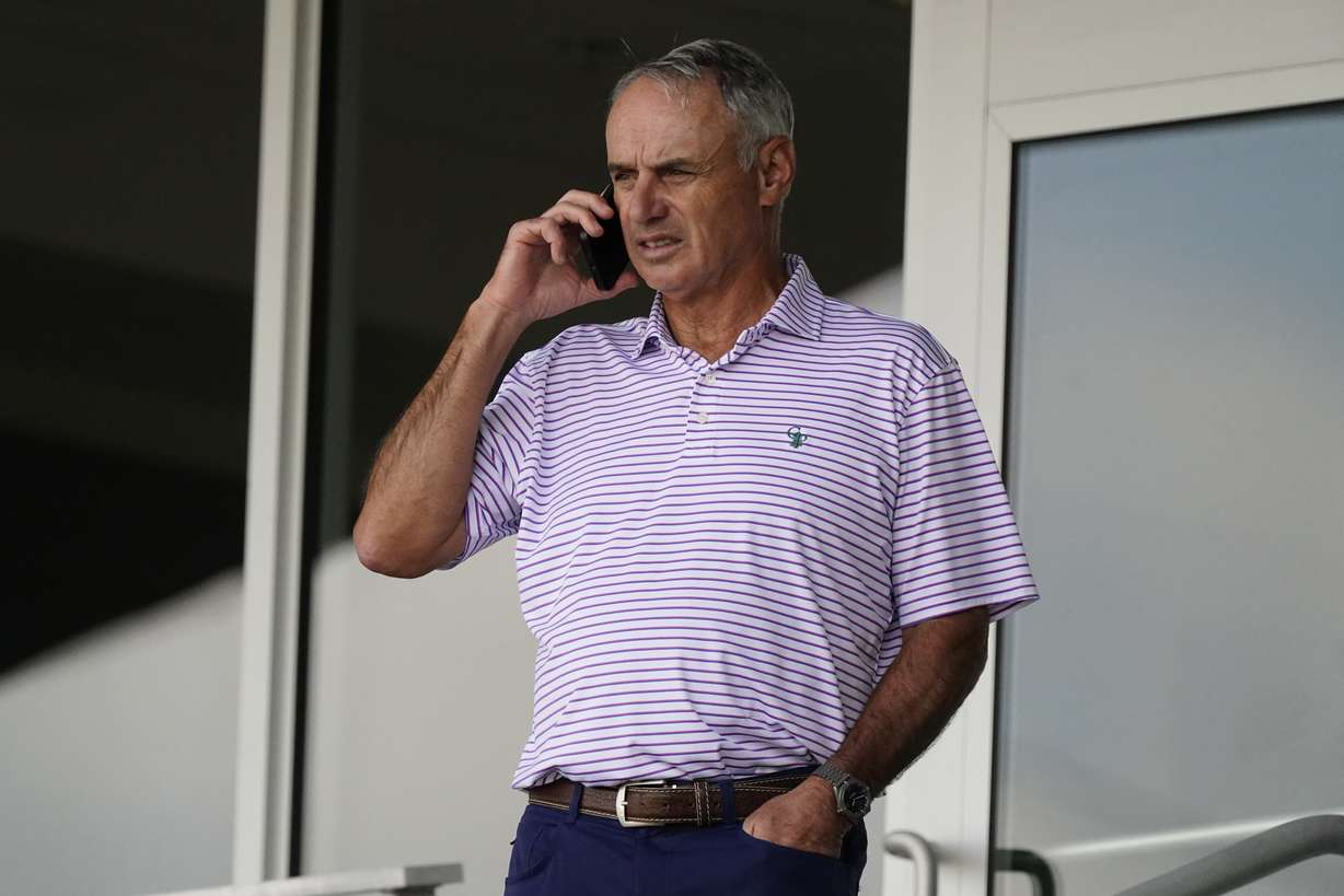 Major League Baseball commissioner Rob Manfred speaks on his phone as he watches a spring training baseball game between the Atlanta Braves and Boston Red Sox on Wednesday, March 10, 2021, in Fort Myers, Fla.