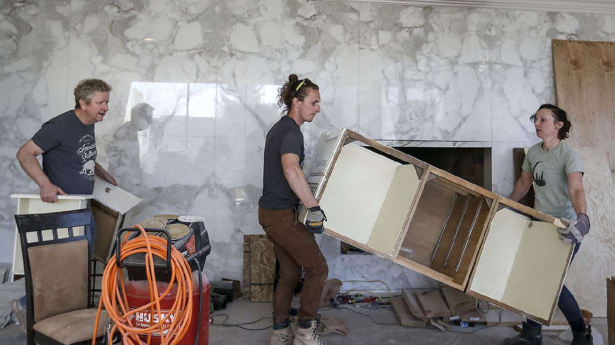 Val Johnson, left, and his children, Eric Johnson and
Jenny Hogsett, remove cabinets from the home they are remodeling in
the St. Mary’s neighborhood of Salt Lake City on Thursday, April 1,
2021. Johnson said he was shocked when a title company sent him
covenants with racial restrictions for a house in Salt Lake City’s
East Bench neighborhood last year.
