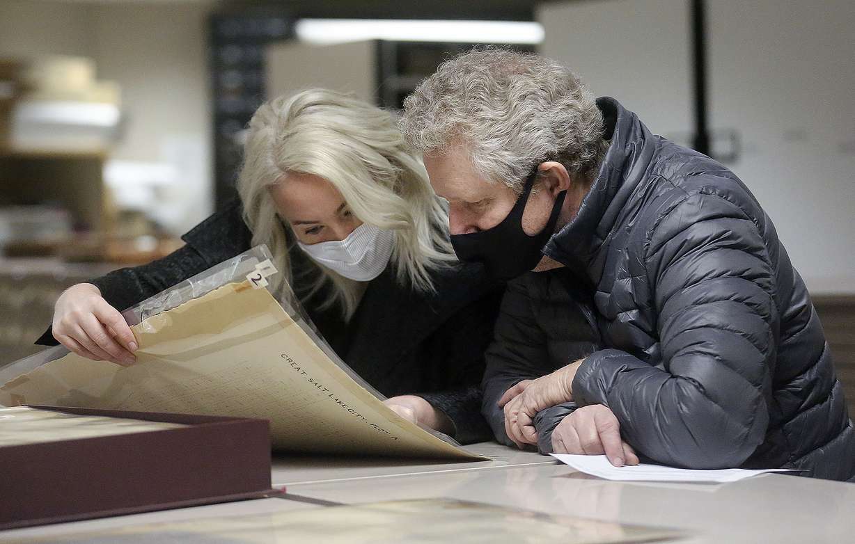Salt Lake County Recorder Rashelle Hobbs, left, shows Val Johnson historical records from the 1850s at the Salt Lake County Recorder’s Office in Salt Lake City on Friday, April 2, 2021. Johnson submitted an affidavit voiding discriminating language on a deed to a property he owns.