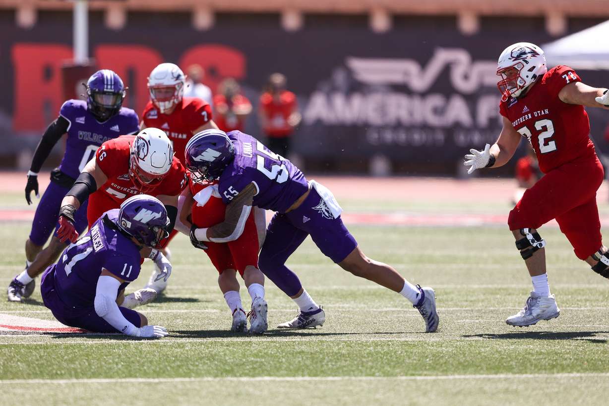 Weber State's Sherwin Lavaka (55) and Conner Mortensen (11) make a tackle during the Wilcats' 19-16 win over Southern Utah, Saturday, April 3, 2021 in Cedar City.