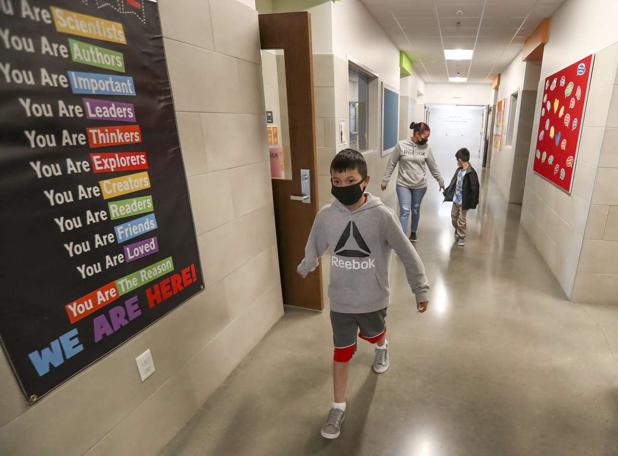 Heidy Melgar, back left, picks up sons Mario, front, and Julian from Neighborhood House in Salt Lake City on Tuesday, March 30, 2021. Neighborhood House provides preschool, youth programs and adult care for its clients.