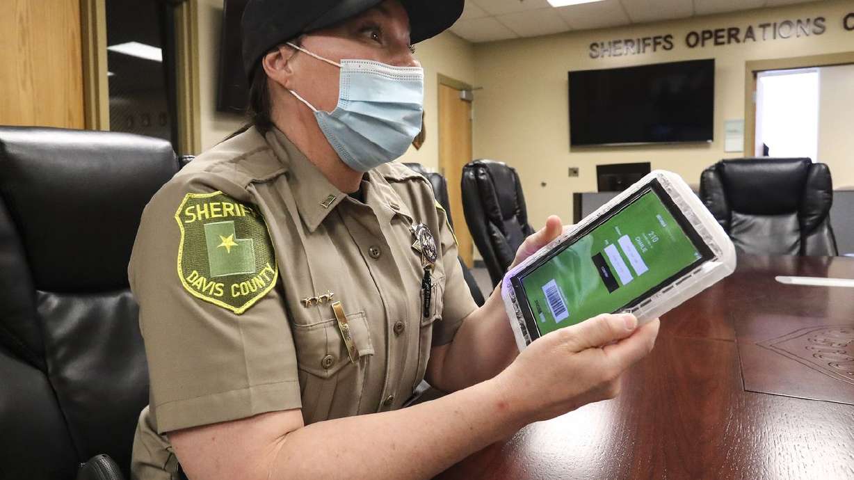 Davis County Sheriff’s Lt. DeeAnn Servey holds a tablet
that is issued to inmates when they’re booked into jail while
discussing the benefits of the device during an interview at the
Farmington facility on Thursday, March 18, 2021.