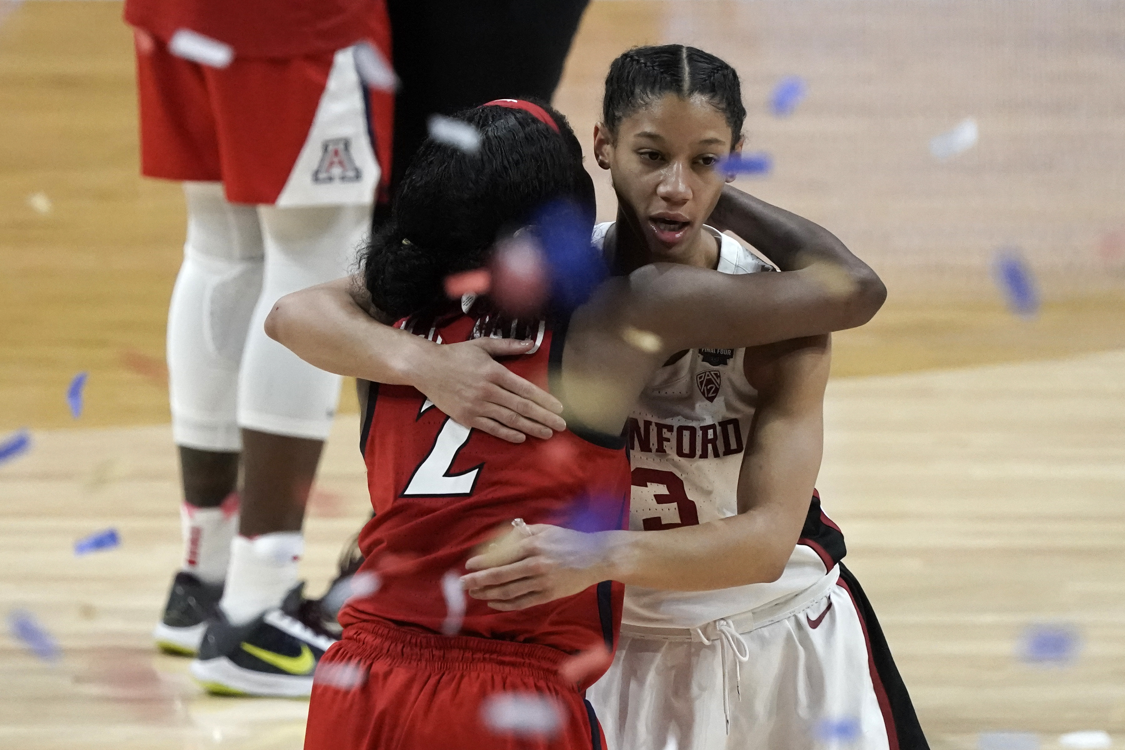 Arizona guard Aari McDonald (2) gets a hug from Stanford guard Anna Wilson (3) at the end of the championship game in the women's Final Four NCAA college basketball tournament, Sunday, April 4, 2021, at the Alamodome in San Antonio. Stanford won 54-53.