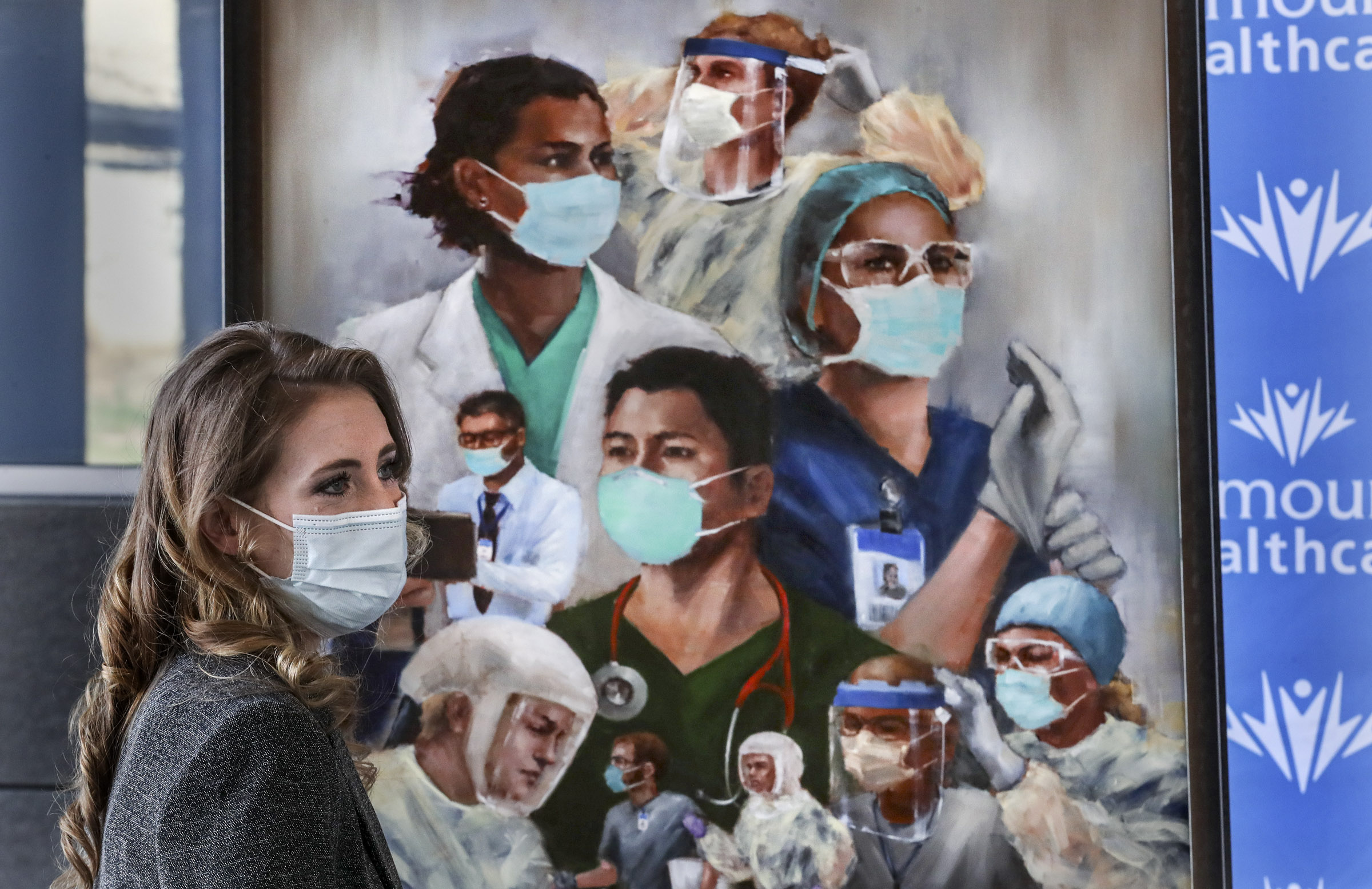 Utah artist Heather Olsen stands with her painting, âTogether We Can Do This,â as it is presented to caregivers at the Intermountain Transformation Center in Murray on Monday, April 5, 2021. Olsen painted the work to honor Utah caregivers for their dedication, commitment,, and heroics in saving countless lives during the pandemic. Copies of the painting will be displayed in Intermountain hospitals across the state.