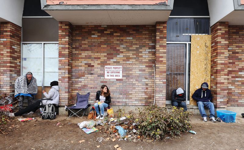Homeless persons sit in a closed business on North
Temple in Salt Lake City on Tuesday, April 6, 2021. Salt Lake City
Mayor Erin Mendenhall spoke during a press conference on her vision
for providing community resources and increased
safety.