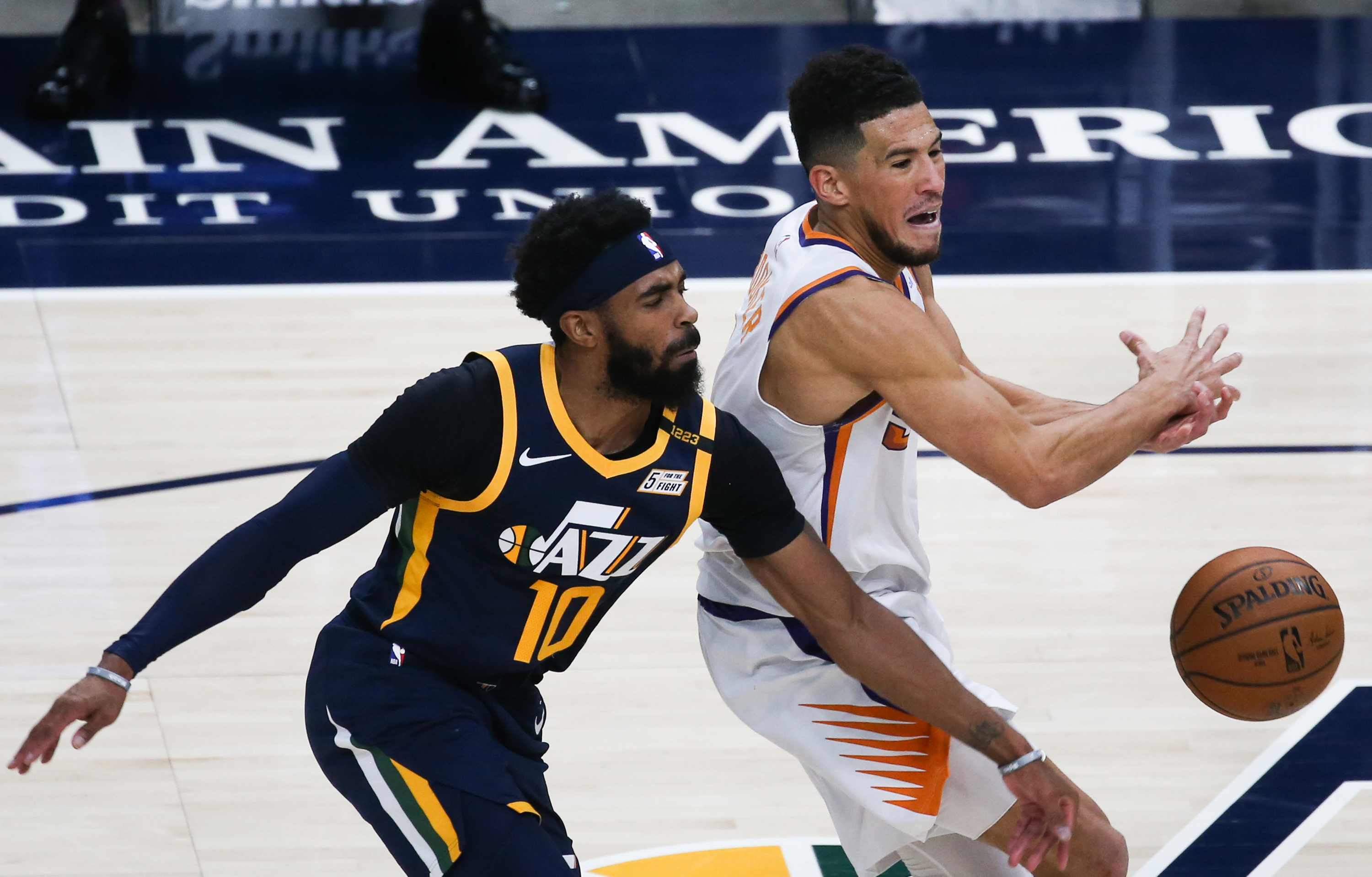 Utah Jazz guard Mike Conley (10) blocks the dribble from Phoenix Suns guard Devin Booker (1) during an NBA basketball game at Vivint Smart Home Arena in Salt Lake City on Thursday, Dec. 31, 2020.