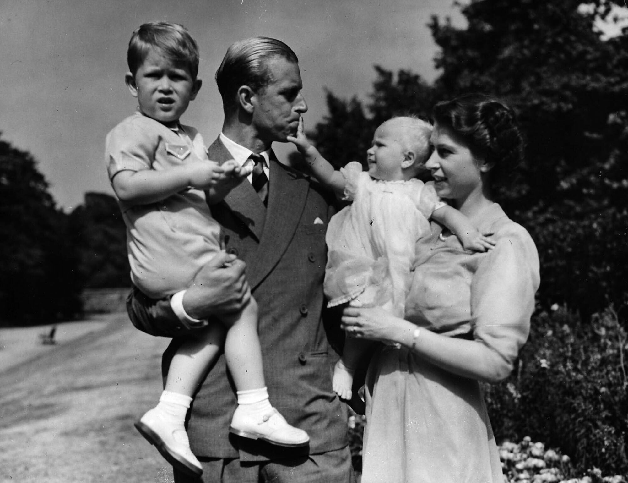 FILE - In this Aug. 1951 file photo, Princess Elizabeth stands with her husband the Duke of Edinburgh and their children Prince Charles and Princess Anne at the couple's London residence at Clarence House.