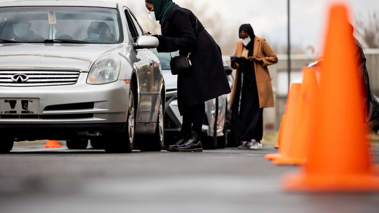 Asma Dahir directs cars during a COVID-19 vaccination event at the Khadeeja Islamic Center and Mosque in West Valley City on Friday, March 26, 2021.