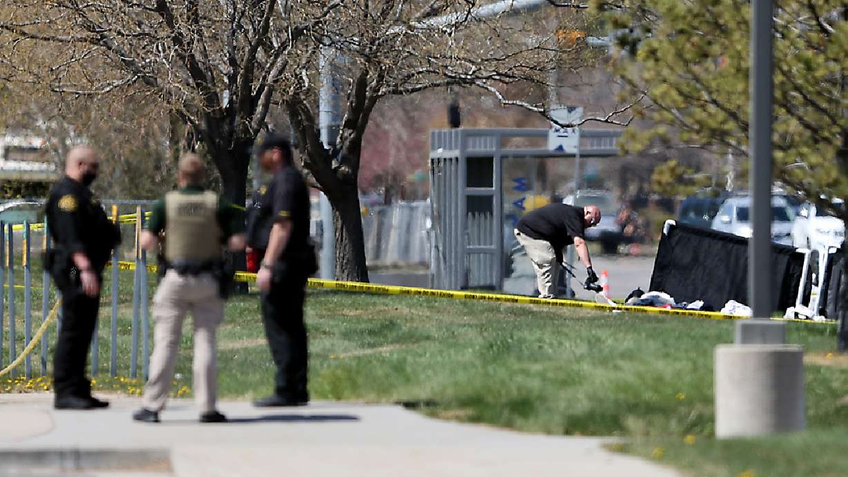 A crime scene photographer takes photos of the area where two Salt Lake County sheriff's deputies were shot and a gunman was shot and killed in front of the Salt Lake County Sheriffâ??s Office building in South Salt Lake on Saturday, April 10, 2021.