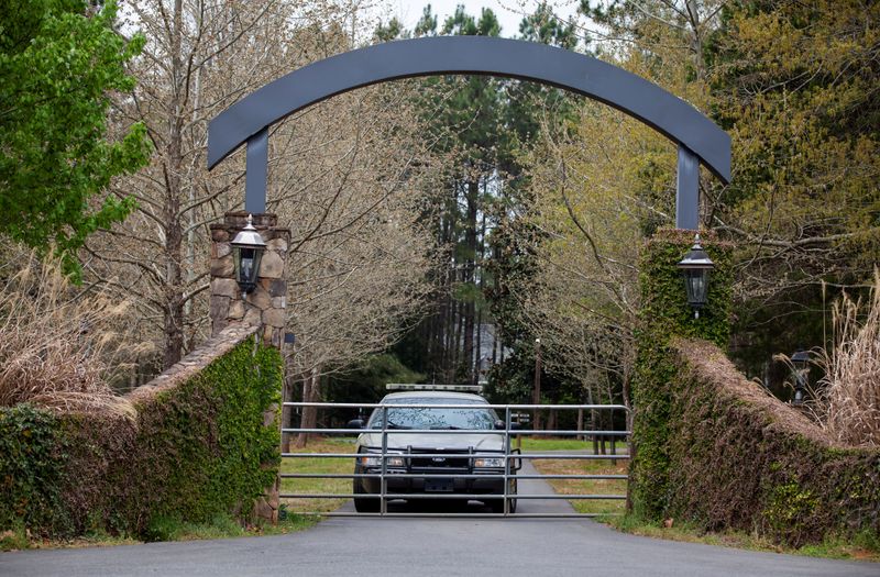 FILE PHOTO: A member of the York County Sheriff's Office guards the entrance to the home where prominent physician Dr. Robert Lesslie, his wife, two grandchildren and another man were shot and killed by former NFL player Phillip Adams in Rock Hill, South Carolina, U.S. April 8, 2021. REUTERS/Sam Wolfe/File Photo