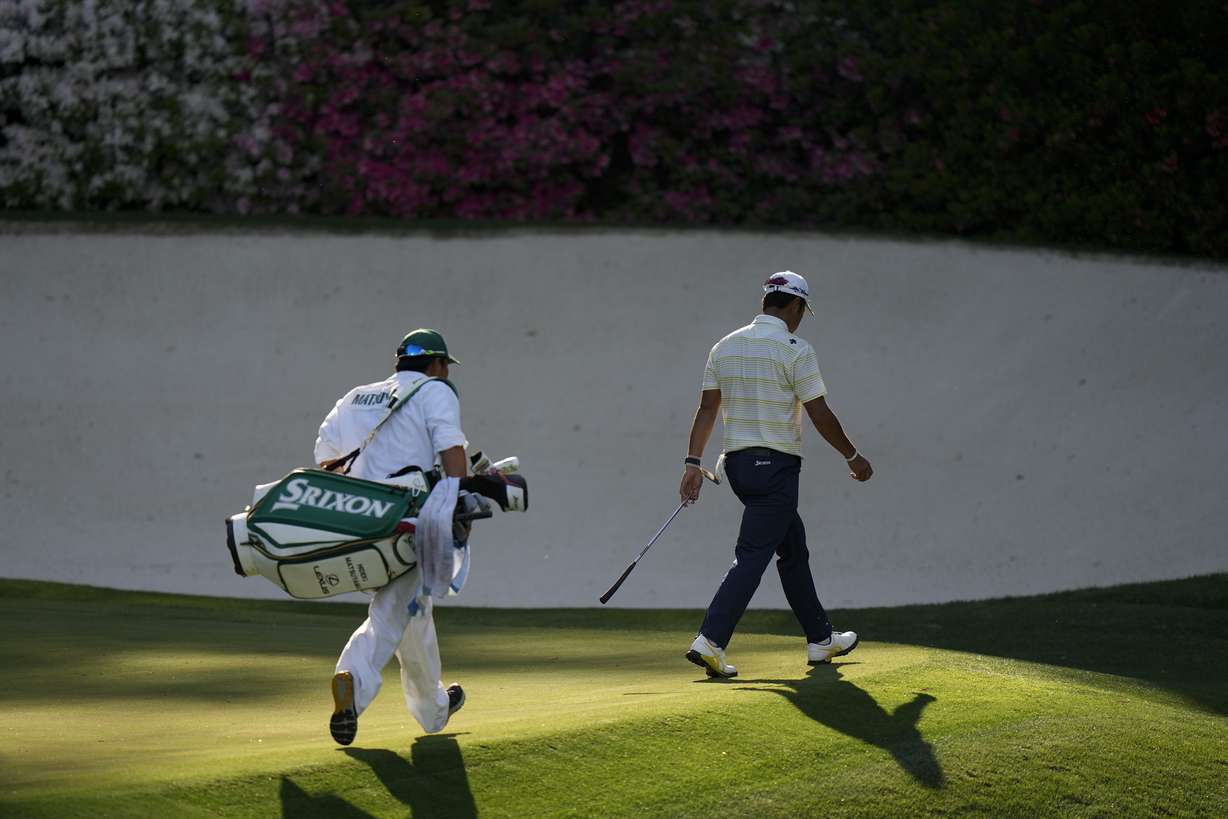 Hideki Matsuyama, of Japan, is followed by his caddie Shota Hayafuji as he walks off the 13th green during the final round of the Masters golf tournament on Sunday, April 11, 2021, in Augusta, Ga.