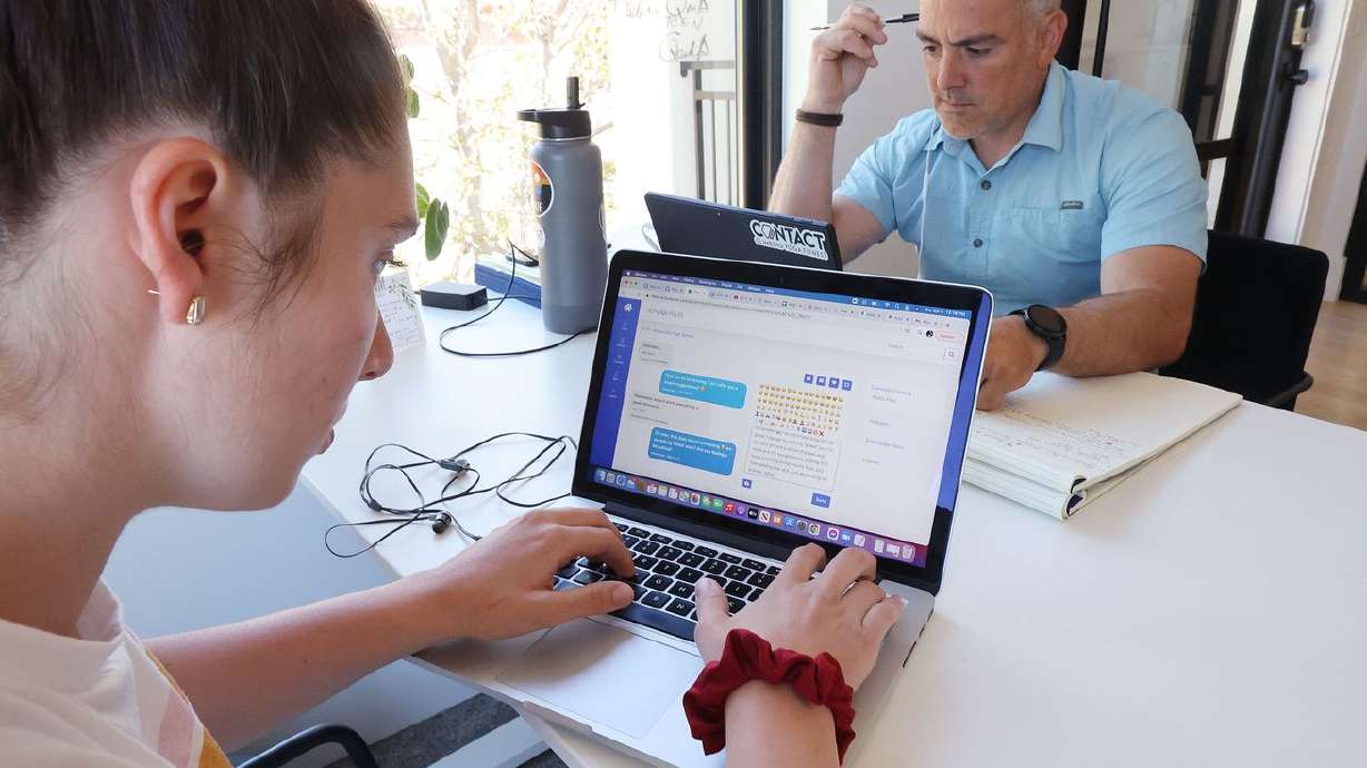 Aydia Melo, a SchoolPulse positive intervention team
member, left, and her father, SchoolPulse psychologist Iuri Melo,
work with students via text in St. George on Thursday, April 8,
2021. SchoolPulse contracts with junior and high schools to offer
counseling and mental health resources delivered by text. More than
20 schools are using it with thousands of students.