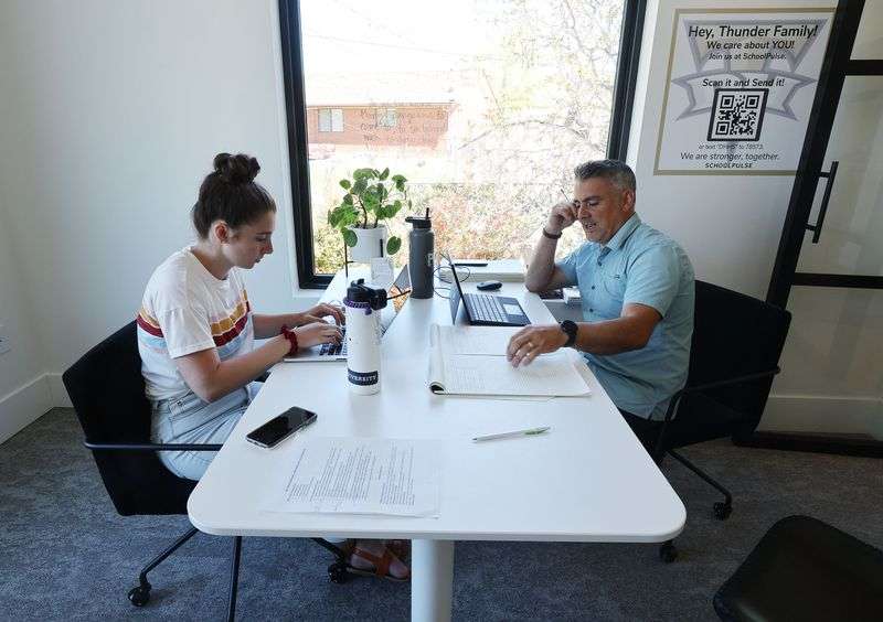 Aydia Melo, a SchoolPulse positive intervention team
member, left, and her father, SchoolPulse psychologist luri Melo,
work with students via text in St. George on Thursday, April 8,
2021.