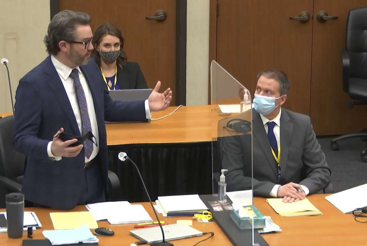 In this image from video, defense attorney Eric Nelson, left, discusses motions before the court as defendant, former Minneapolis police officer Derek Chauvin, right, and Nelson's assistant Amy Voss, back, listen, Monday, April 12, 2021, as Hennepin County Judge Peter Cahill presides over the trial of Chauvin at the Hennepin County Courthouse in Minneapolis.