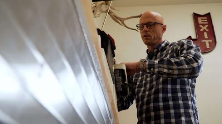 Darin Kirkham sands down a pen in a room attached to his garage.
