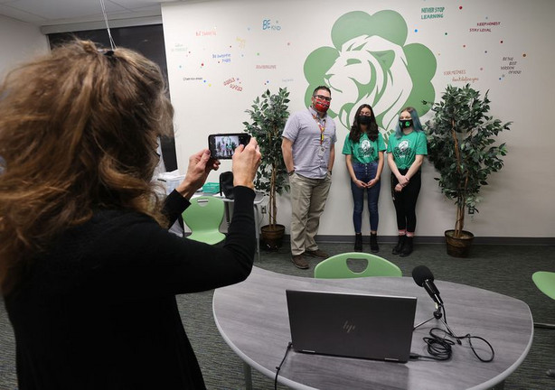 Sandra Riesgraf, director of communications for the Jordan School District, left, takes a photo of West Jordan Middle School teacher William Shields and students Emma Sosa and Austin Poitras after they joined Gov. Spencer Cox via Zoom in West Jordan on Tuesday, April 13, 2021. On Tuesday, Cox answered questions submitted by middle and high school student leaders from across the state in his first student town hall.