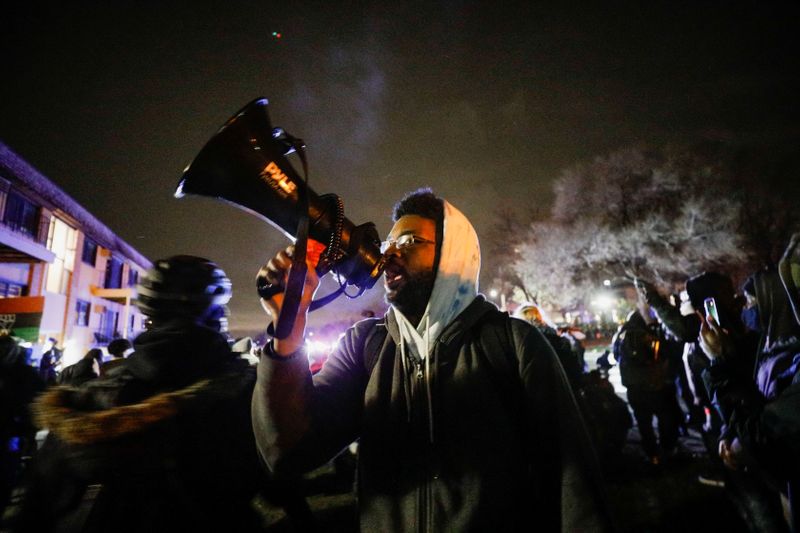 A person uses a megaphone as demonstrators confront law enforcement officers during a rally days after Daunte Wright, 20, was shot and killed by former Brooklyn Center Police Officer Kim Potter, in Brooklyn Center, Minnesota, U.S., April 13, 2021. REUTERS/Nick Pfosi