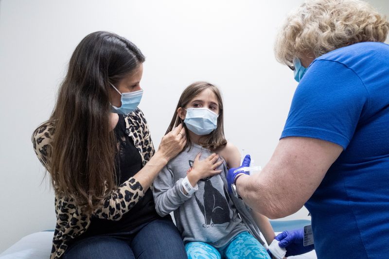 FILE PHOTO: Marisol Gerardo, 9, is held by her mother as she gets the second dose of the Pfizer coronavirus disease (COVID-19) vaccine during a clinical trial for children at Duke Health in Durham, North Carolina, U.S., April 12, 2021. Shawn Rocco/Duke Health/Handout via REUTERS