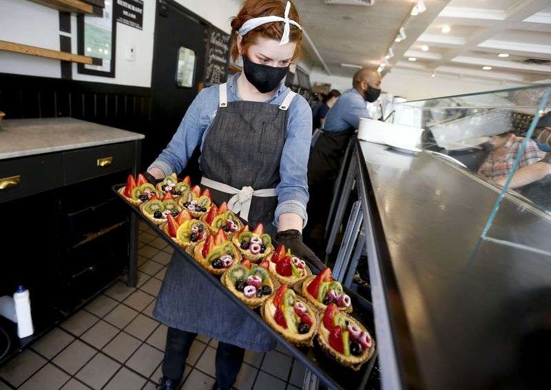 Claire Isom places fruit tarts into a display case at
Gourmandise in Salt Lake City on Thursday, April 8, 2021. Despite
record numbers of Utahns filing for jobless benefits every week,
some Utah employers are having trouble finding workers to fill open
positions.