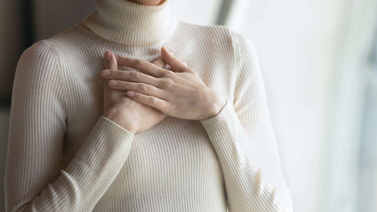 Close up focus on female hands, folded on chest. Happy young woman employee feeling thankful indoors, praying for good luck on important business meeting, dreaming of future, appreciation concept. forgiveness