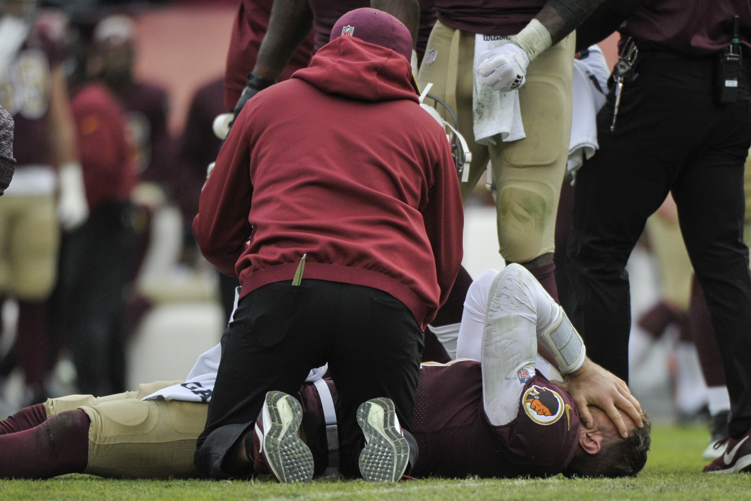 FILE - Washington Redskins quarterback Alex Smith, bottom, reacts after an injury during the second half of an NFL football game against the Houston Texans in Landover, Md., in this Sunday, Nov. 18, 2018, file photo. Smith announced his retirement Monday, April 19, 2021, on Instagram, saying he still has plenty of snaps left him just shy of his 37th birthday but is calling it quits to enjoy time with his family. Smith earned AP Comeback Player of the Year honors for getting back on the field last season, two years removed from his gruesome injury that required 17 surgeries to repair. (AP Photo/Mark Tenally, File) [Apr-19-2021]