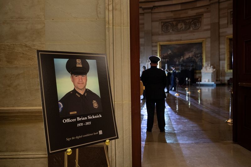 FILE PHOTO: A picture of of Capitol Police officer Brian Sicknick, who died on Jan. 7 from injuries he sustained while protecting the U.S. Capitol during the Jan. 6 attack on the building, is seen as people wait for his remains to arrive to lay in honor in the Rotunda of the U.S. Capitol building in Washington, DC, U.S. February 2, 2021. Brendan Smialowski/Pool via REUTERS
