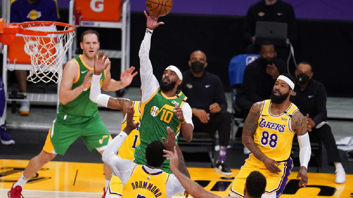 Utah Jazz guard Mike Conley (10) shoots over Los Angeles Lakers center Andre Drummond (2) during the first half of an NBA basketball game Monday, April 19, 2021, in Los Angeles. (AP Photo/Marcio Jose Sanchez)