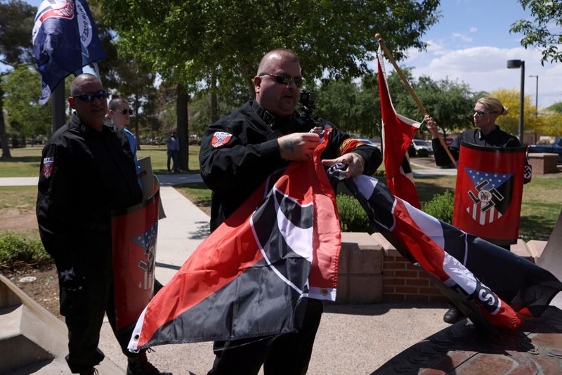 FILE PHOTO: Burt Colucci of the white nationalist group National Socialist Movement destroys a flag of the anti-facist movement during a rally in Phoenix, Arizona, U.S., April 17, 2021. Picture taken April 17, 2021. REUTERS/Jim Urquhart/File Photo