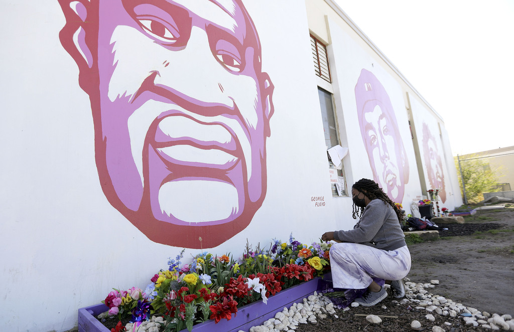 Ashley Cleveland brings flowers to the George Floyd mural on the corner of 800 South and 300 West after a jury found former Minneapolis police officer Derek Chauvin guilty in the killing of George Floyd in Salt Lake City on Tuesday, April 20, 2021.