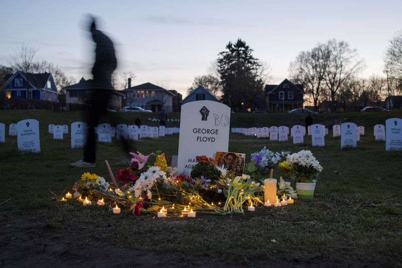A local resident walks along the "Say Their Names" cemetery on the day of verdict in the trial of former Minneapolis police officer Derek Chauvin, found guilty of the death of George Floyd, at George Floyd Square in Minneapolis, Minnesota, U.S., April 20, 2021. REUTERS/Carlos Barria
