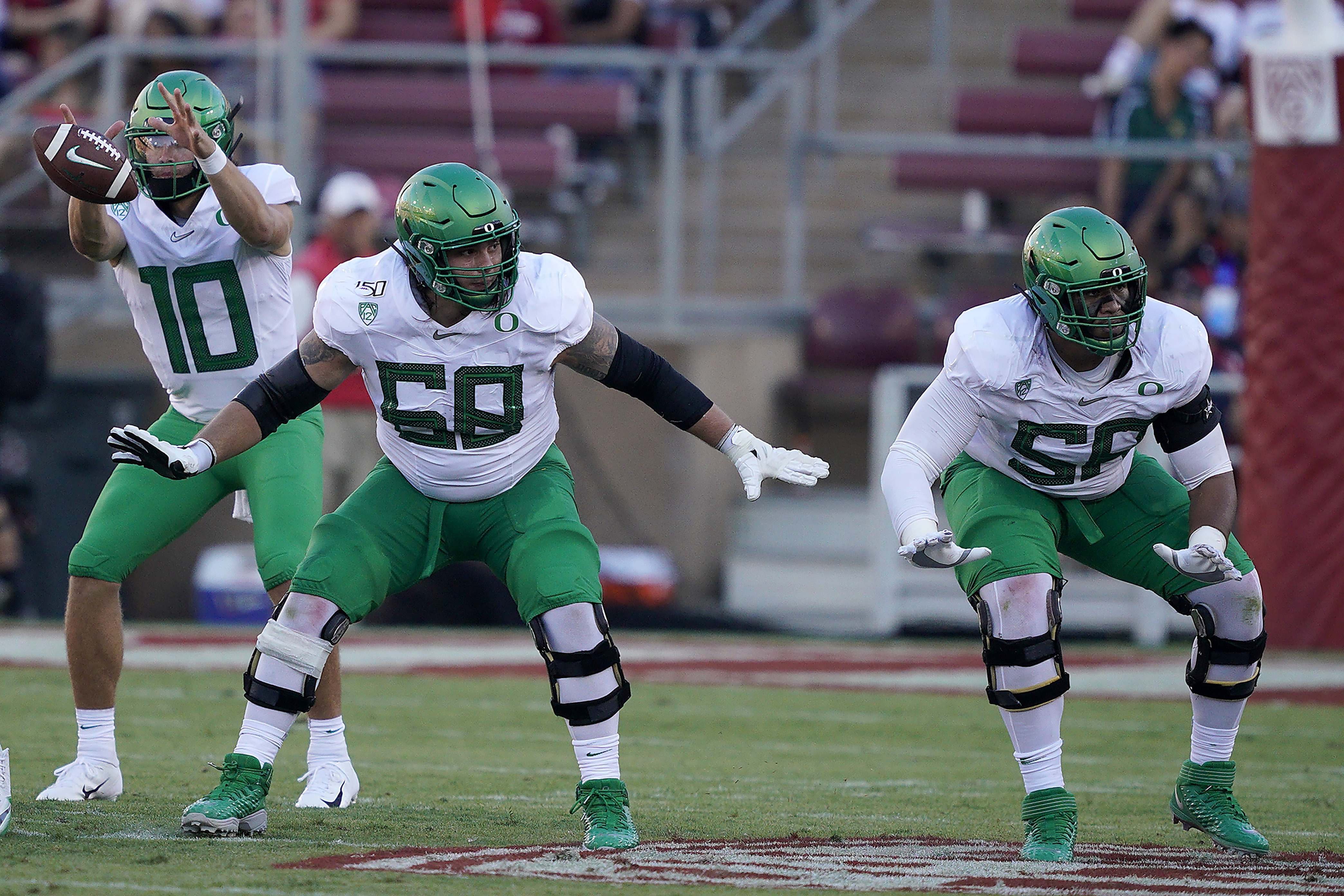 This Sept. 21, 2019, file photo shows Oregon offensive linemen Shane Lemieux (68) and Penei Sewell (58) blocks for quarterback Justin Herbert (10) against Stanford during the first half of an NCAA college football game in Stanford, Calif.