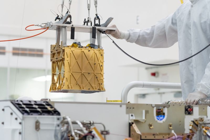 FILE PHOTO: Technicians at NASA's Jet Propulsion Laboratory lower the Mars Oxygen In-Situ Resource Utilization Experiment (MOXIE) instrument into the belly of the Perseverance rover in an undated photograph in Pasadena, California, U.S. NASA/JPL-Caltech/Handout via REUTERS