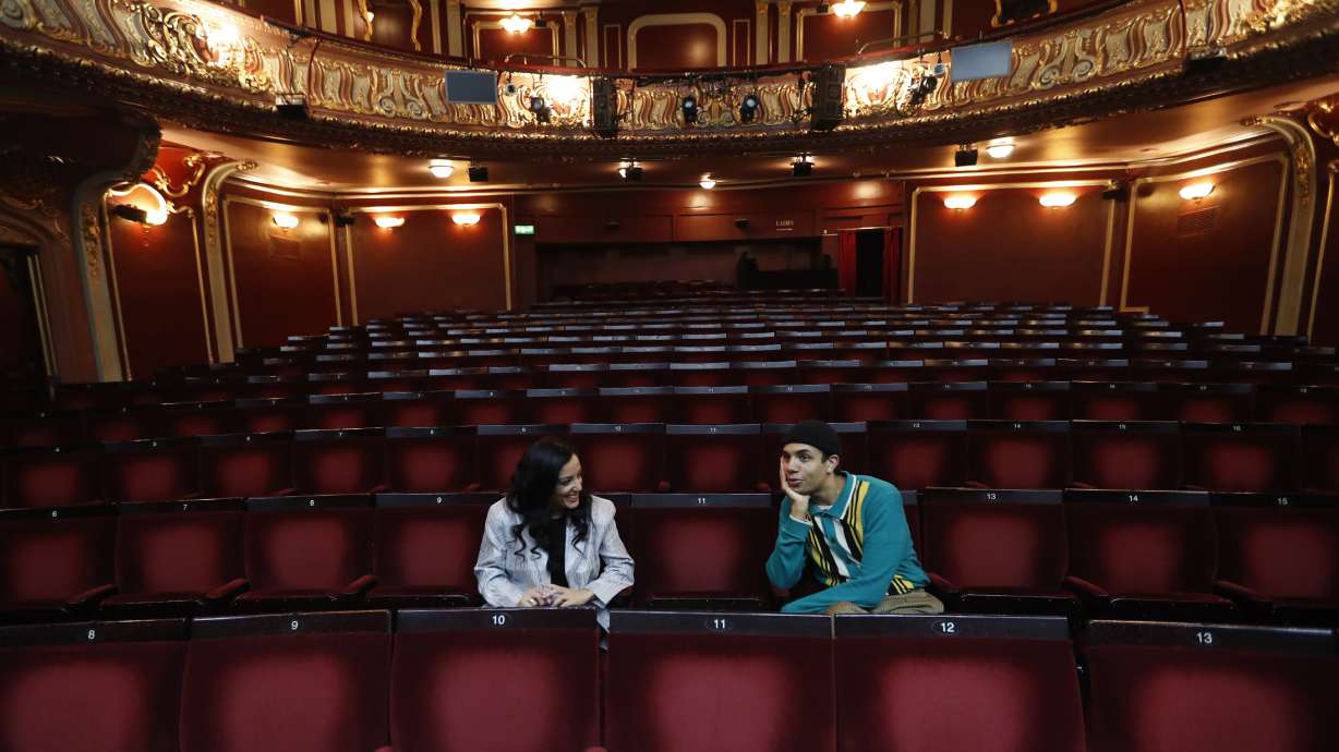 Leading actors of the musical "Everybody's Talking About Jamie." Noah Thomas, right, who plays Jamie, and Hiba Elichike, who portrays Pritti Pasha, speak to the Associated Press in the auditorium of the Apollo Theater where the musical is preparing to continue its run in London, Tuesday, April 20, 2021. (AP Photo/Alastair Grant)