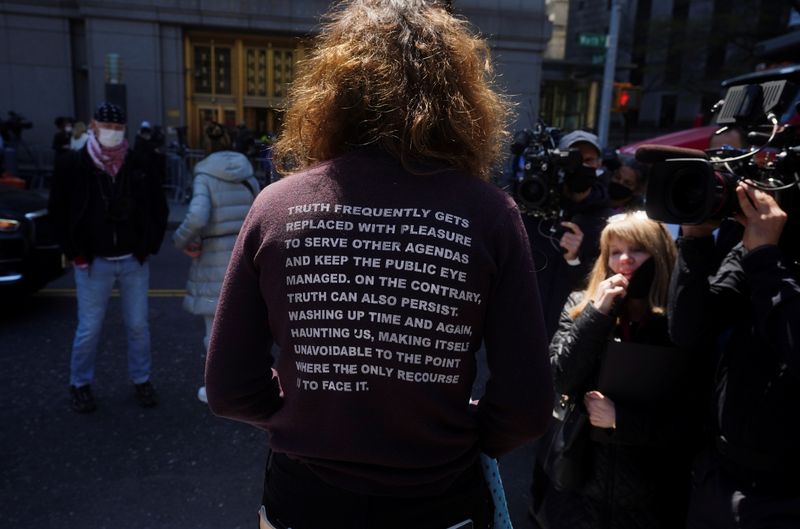 A protester stands outside Manhattan Federal Court ahead of Ghislaine Maxwell's arraignment on a new indictment, in the Manhattan borough of New York City, New York, U.S. April 23, 2021. REUTERS/Carlo Allegri