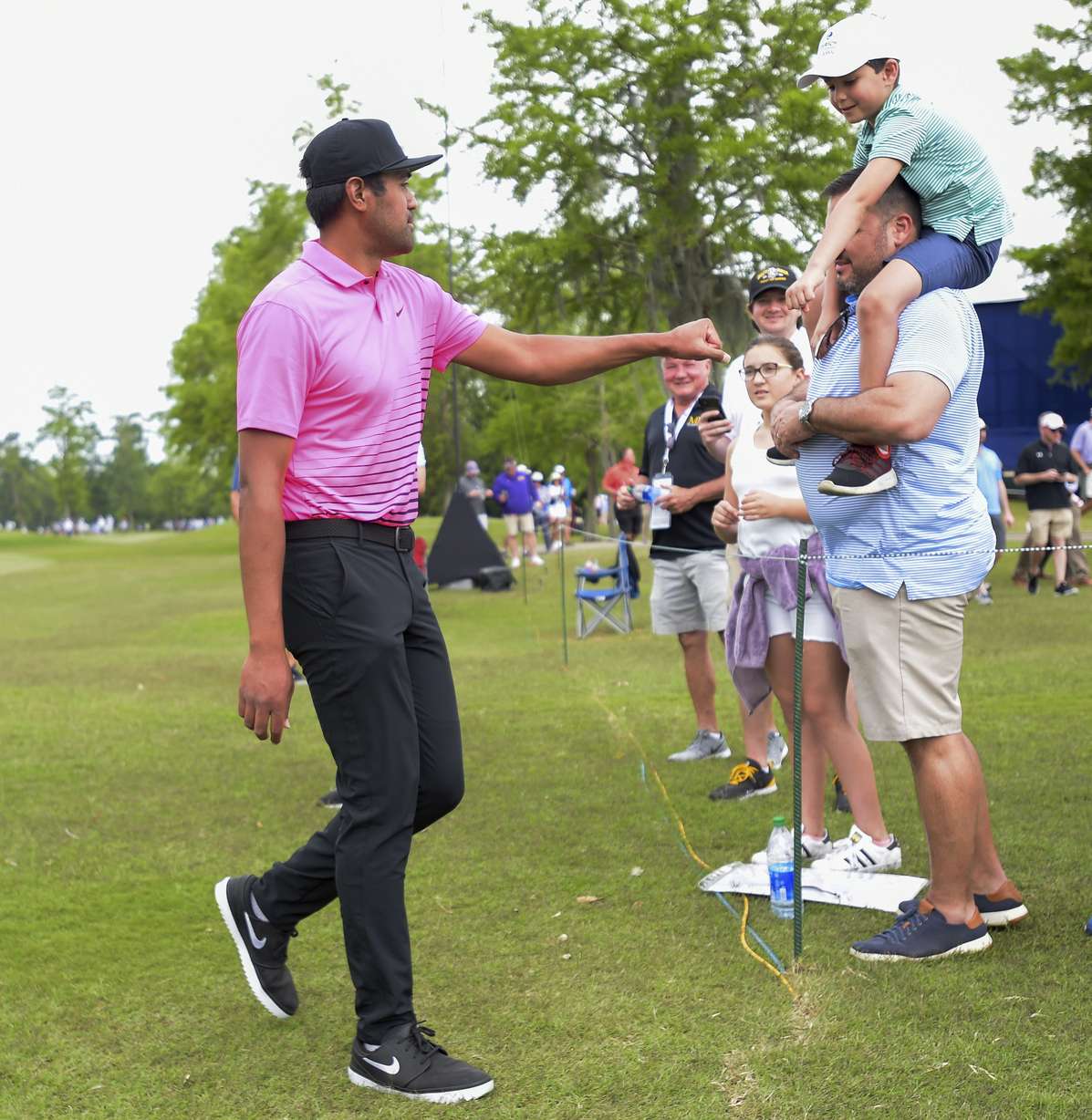 Tony Finau bumps fists with a young fan during the second round of the Zurich Classic golf tournament at TPC Louisiana in Avondale, La., Friday, April 23, 2021.