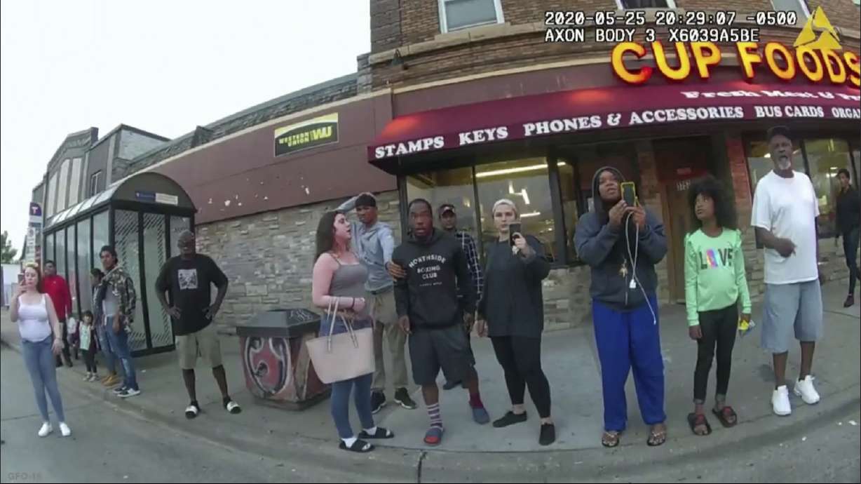 This May 25, 2020, file image from a police body camera shows bystanders including Alyssa Funari, left filming, Charles McMillan, center left in light-colored shorts, Christopher Martin center in gray, Donald Williams, center in black, Genevieve Hansen, fourth from right filming, Darnella Frazier, third from right filming, as former Minneapolis police officer Derek Chauvin was recorded pressing his knee on George Floyd's neck for several minutes in Minneapolis.