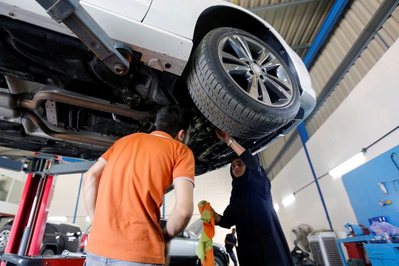 Huda al-Matrooshi, 36, an Emirati woman who owns and runs a car repair garage, checks a car at her garage in Sharjah, United Arab Emirates April 21, 2021.  REUTERS/Rula Rouhana