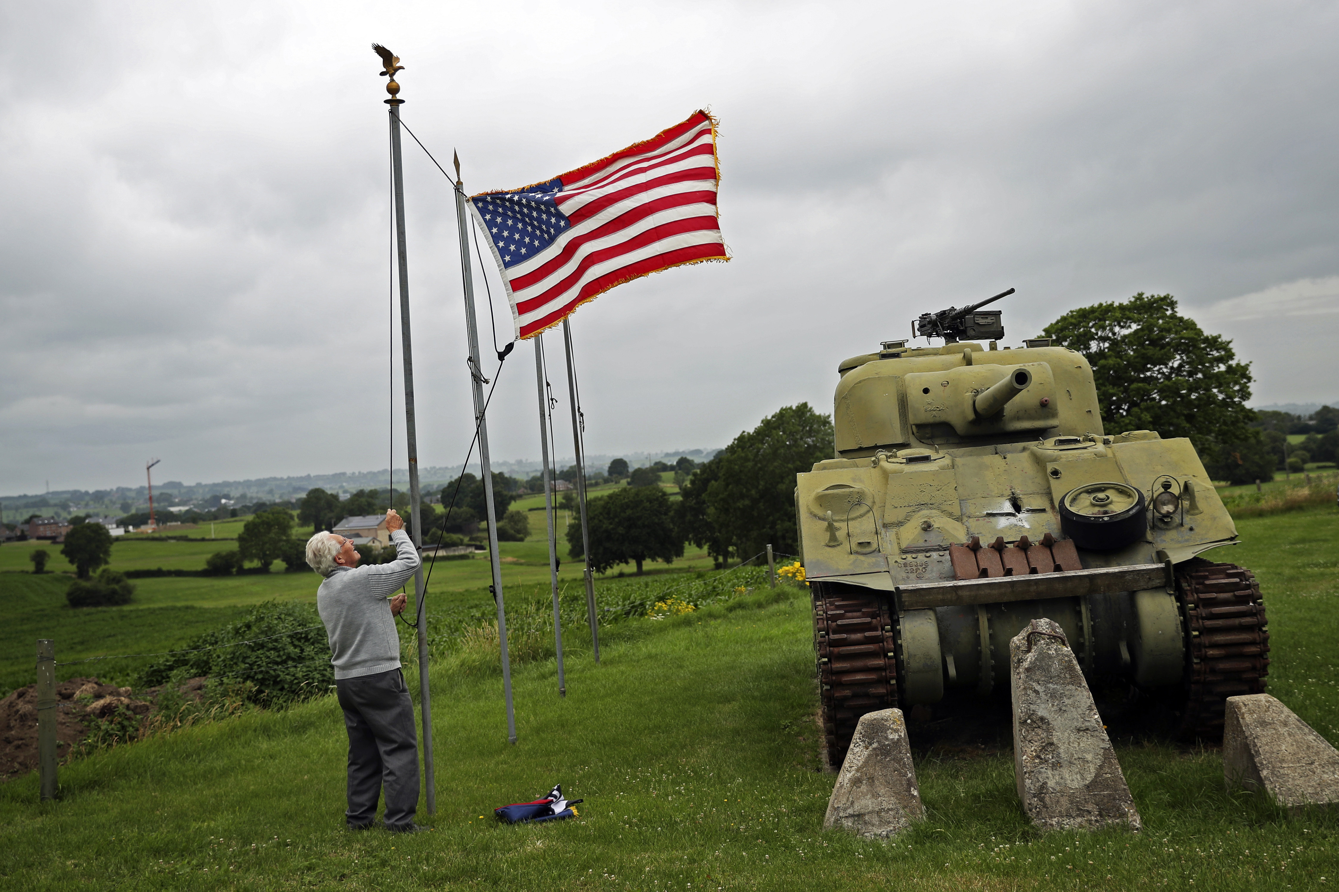 FILE - In this Wednesday, July 1, 2020 file photo, Marcel Schmetz raises the US flag next to a WWII American Sherman tank at his Remember Museum 39-45 in Thimister-Clermont, Belgium. Tourists from the United States who are fully vaccinated against COVID-19 could be able to travel across the European Union this summer, officials from the 27-nation bloc said on Monday, April 26, 2021. (AP Photo/Francisco Seco, File) [Apr-26-2021]