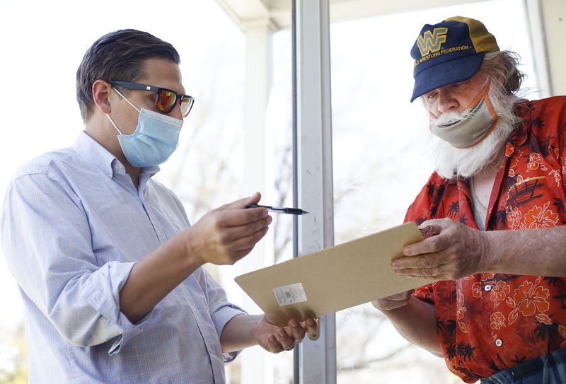 Salt Lake City Council candidate Blake Perez gets a
signature from Lee Parr in Salt Lake City on Friday, April 23,
2021. To qualify for the ballot, council candidates must collect at
least 75 signatures from residents in their district who are at least 18 years old.