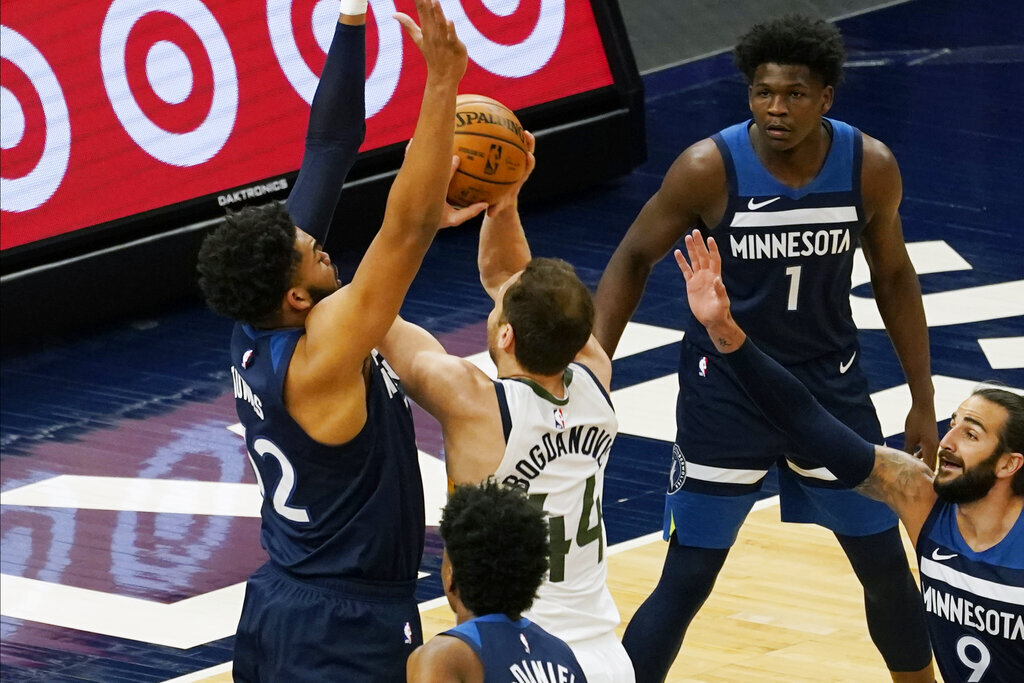 Minnesota Timberwolves' Karl-Anthony Towns , left, defends as Utah Jazz's Bojan Bogdanovic (44) attempts to shoot in the first half of an NBA basketball game, Monday, April 26, 2021, in Minneapolis. (AP Photo/Jim Mone)