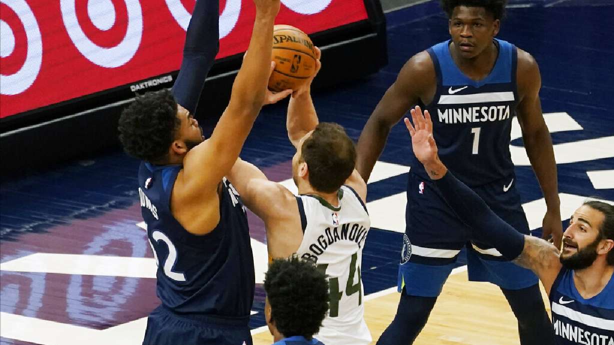 Minnesota Timberwolves' Karl-Anthony Towns , left, defends as Utah Jazz's Bojan Bogdanovic (44) attempts to shoot in the first half of an NBA basketball game, Monday, April 26, 2021, in Minneapolis. (AP Photo/Jim Mone)